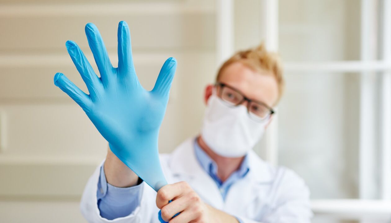 Le médecin met un gant de massage pour prévenir la prostatite